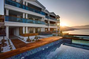 a large building with a swimming pool and the sunset at Meis Exclusive Hotel in Kaş