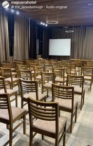 a conference room with chairs and a projector screen at Hotel Mapuera in Oriximiná