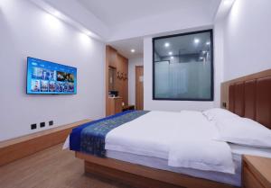 Un dormitorio con una cama grande y una ventana grande. en Lingli Home Hotel, en Dali