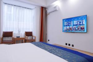 Una habitación de hotel con una cama y dos sillas. en Lingli Home Hotel, en Dali