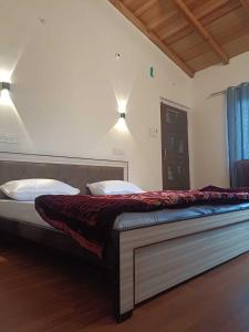 una cama grande en una habitación con dos almohadas en Panchavati Hills Homestay, en Dwārāhāt