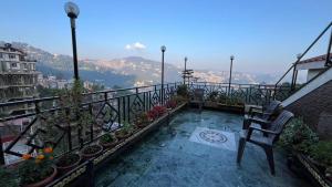 a balcony with a chair and potted plants on it at Swastik Inn in Jāmb +5 photos
