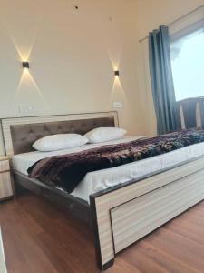 Una cama grande en un dormitorio con ventana. en Panchavati Hills Homestay, en Dwārāhāt