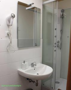 Un baño blanco con lavabo y ducha. en Agriturismo I TRE TIGLI, en Rignano Flaminio