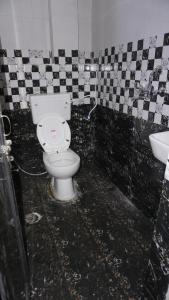 a dirty bathroom with a toilet and a sink at Shri Ashray in Varanasi