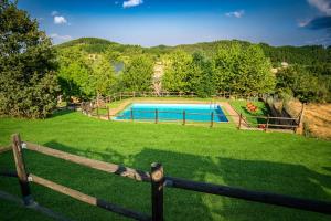 einen Zaun in einem Garten mit Pool in der Unterkunft La Casa del Monte in Ocero