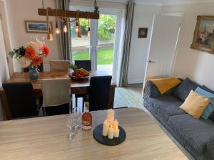 a living room and dining room with a table and a couch at 2 Fernleigh Villas in Perranporth