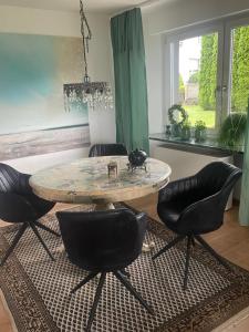 a table and chairs in a living room with a table at Haus Sengbach in Heide +5 photos