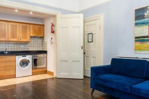 a living room with a blue couch and a washing machine at GuestReady - Quiet Dublin Getaway in Dublin