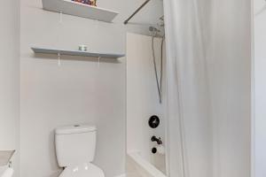 a white bathroom with a toilet and a shower at Modern 1- Queen Bed On Quiet Block in Augusta +12 photos