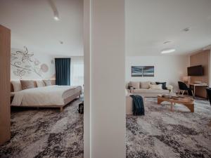 a bedroom with a bed and a living room at Arche Hotel Lotnisko Gdańsk in Gdańsk-Rębiechowo