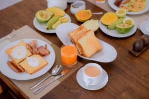 una mesa de madera con platos de comida y tazas de café en Villa 64, en Negombo