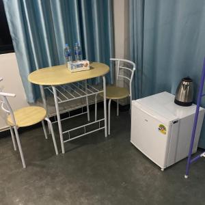 a small table and chairs and a small refrigerator at Saran Hotel krabi Thailand in Krabi town