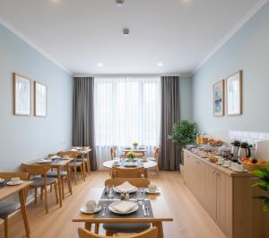 a dining room with tables and chairs and a kitchen at Arsuz Paart Otel in Arsuz +13 photos
