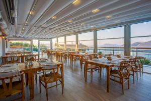 a restaurant with wooden tables and chairs and windows at Meis Exclusive Hotel in Kaş