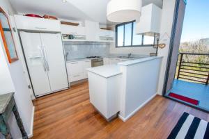 una cucina con elettrodomestici bianchi e pavimento in legno di Driftwood a Boat Harbour