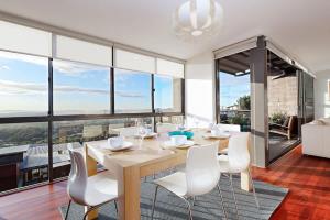 Un comedor con una mesa y sillas blancas. en Sunset Ridge (OMR12A), en Boat Harbour