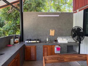 an outdoor kitchen with a counter and a sink at Serenity by the River in Ban Tha Pong (1)