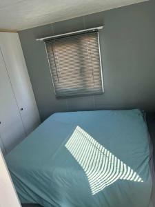a bed in a small room with a window at 8 Berth 3 bed caravan pet friendly TP56 in Chapel Saint Leonards +2 photos