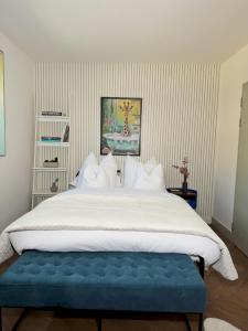 a large bed with a blue bench in a bedroom at London Luxury Apartments in Crystal Palace
