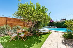 einen Garten mit einem Tisch und Stühlen neben einem Pool in der Unterkunft Villa Victoria, Torremolinos in Torremolinos