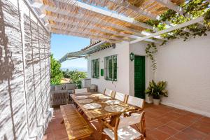 eine Terrasse mit einem Holztisch und Stühlen in der Unterkunft Villa Victoria, Torremolinos in Torremolinos + 13 Fotos