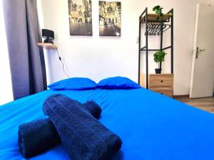 Una cama azul con almohadas azules. en Studio Moderne Bien Pensé, en Elbeuf