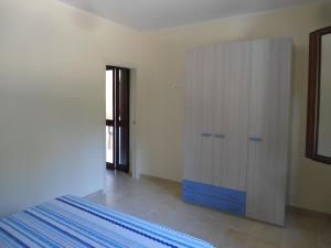 1 dormitorio con armario blanco y cómoda azul en Appartamento Bilocale a 200 m dalla spiaggia en Vieste