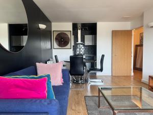 a living room with a blue couch and a table at LIME 2 Bedroom APARTMENT in North Woolwich
