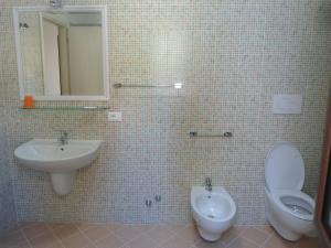 y baño con lavabo, aseo y espejo. en Appartamento Bilocale a 200 m dalla spiaggia en Vieste