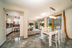 a kitchen and living room with a table and chairs at Villa Drogarati Retreat by Villa Plus in Chaliotata
