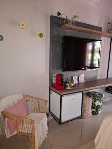 a living room with a flat screen tv on a wall at Casa Jabuticaba Refúgio e Hospedagem in São Miguel Arcanjo