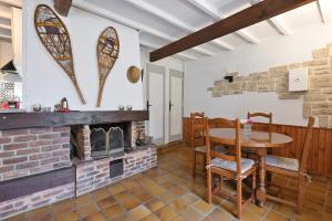 a dining room with a table and a fireplace at Sport et réconfort en Couserans in Soulan