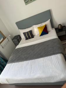 ein Schlafzimmer mit einem großen Bett mit drei Kissen in der Unterkunft Chambre familiale lumineuse et spacieuse in Lille