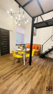 un salon avec une table et des chaises jaunes dans l'établissement Смарт квартира в самому центрі міста, à Tchernivtsi