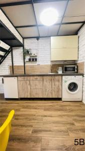 une cuisine avec une machine à laver et un lave-linge dans l'établissement Смарт квартира в самому центрі міста, à Tchernivtsi