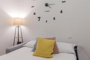 a bedroom with a bed with a clock on the wall at Casa Magenta a 4 minuti dalla metro WIFI & AC in Milan