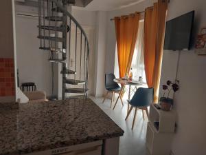 a kitchen with a spiral staircase and a table and chairs at Ático acogedor, céntrico y a 2 min de la playa. in Fuengirola