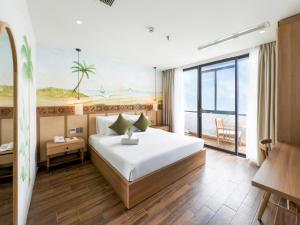 a hotel room with a bed and a balcony at Gold Central Hotel by Haviland in Danang