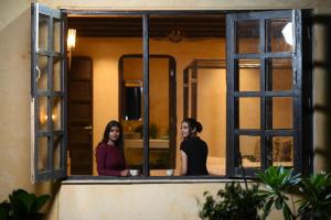 two women standing in front of a window at Mura Yoga Villa in Nauratori