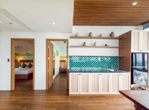 a kitchen with a sink and a room with a bed at Gold Central Hotel by Haviland in Da Nang +70 photos
