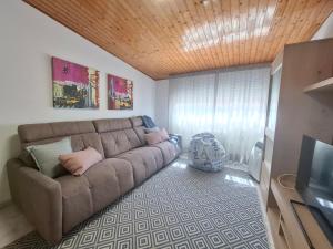a living room with a couch and a television at O Enxido - Vive dentro de la muralla de Ribadavia in Ribadavia