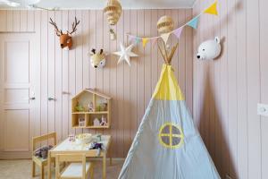 - une chambre pour enfants avec une table et une tente dans l'établissement Reindeerly Cottage Hosted by Hygge Host, à Rovaniemi