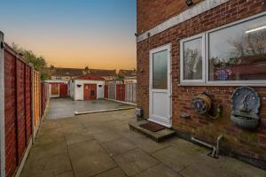 une maison en briques avec une porte blanche et une cour dans l'établissement Contractor Stay, Discounts, Free Parking, Local Shops, à Wyken