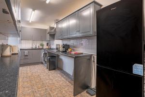 Il comprend une grande cuisine équipée d'un réfrigérateur noir et de placards. dans l'établissement Contractor Stay, Discounts, Free Parking, Local Shops, à Wyken 8 autres photos