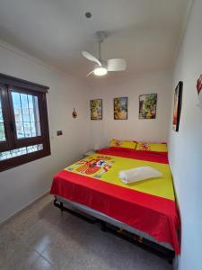 サン・ペドロ・デル・ピナタルにあるCasa Flamingo - Corner house near beach & boulevard with sea & salt lake viewのベッドルーム1室(大型ベッド1台、赤と黄色の毛布付)