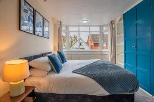 une chambre avec un lit avec des armoires bleues et une fenêtre dans l'établissement Contractor Stay, Discounts, Free Parking, Local Shops, à Wyken