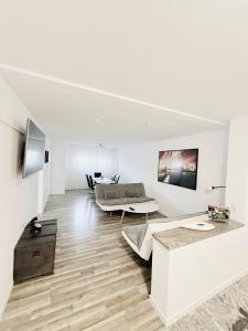 Una sala de estar blanca con un sofá y un televisor. en Ferienwohnung Hecker, en Rastatt
