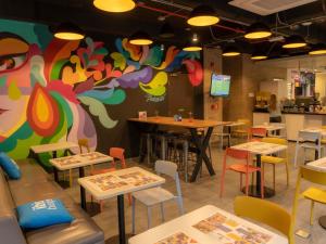 a restaurant with tables and chairs and a colorful wall at ibis budget Bogota Marly in Bogotá +98 photos