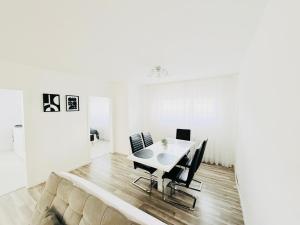 a white dining room with a table and chairs at Ferienwohnung Hecker in Rastatt